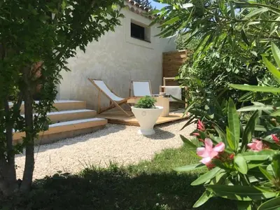 a backyard with a patio with a chair and a toilet at La Maison 1440 in LʼIsle-sur-la-Sorgue