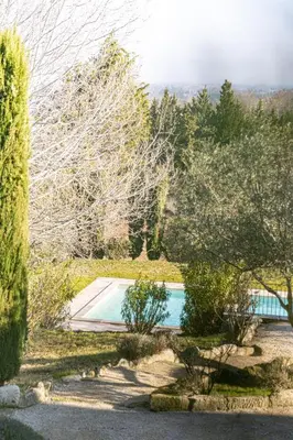 a swimming pool in the middle of a garden at Maison Bournissac in Noves