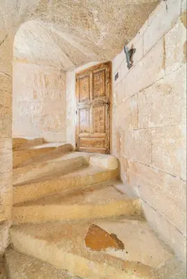 an empty room with a wooden door and stairs at Le Bonheur -studio terrasse centre-ville - in LʼIsle-sur-la-Sorgue