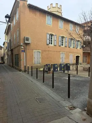 an empty street in front of a building at Le Bonheur -studio terrasse centre-ville - in LʼIsle-sur-la-Sorgue