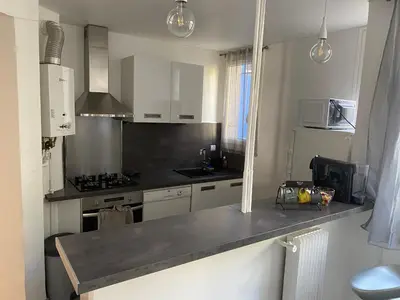 a kitchen with white cabinets and a counter top at Appartement proche centre ville in Aix-en-Provence