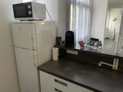a kitchen with a refrigerator and a counter with a microwave at Appartement proche centre ville in Aix-en-Provence