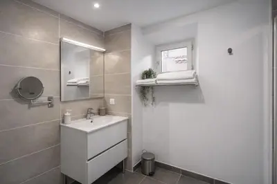 a white bathroom with a sink and a mirror at SOUS LES PLATANES in Velaux