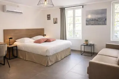 a bedroom with a large bed and a couch at SOUS LES PLATANES in Velaux