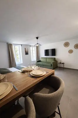 a living room with a wooden table and chairs at SOUS LES PLATANES in Velaux