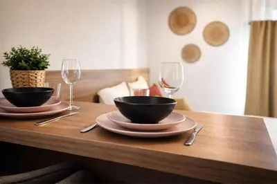 a wooden table with two bowls and wine glasses at SOUS LES PLATANES in Velaux