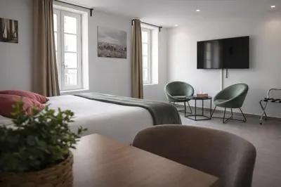 a hotel room with a bed and two chairs and a table at SOUS LES PLATANES in Velaux