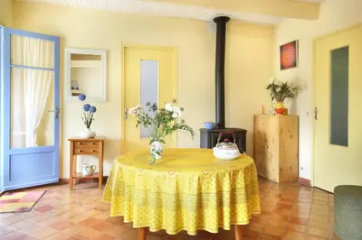 a living room with a table with a yellow table cloth at La Cerisaie, maison spacieuse en Lubéron in Saint-Martin-de-Castillon