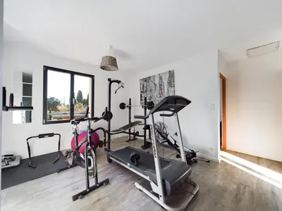 a gym with treadmills and exercise bikes in a room at Mas des Oliviers in Eyragues
