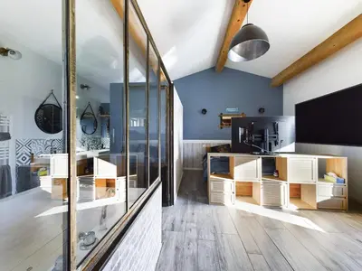 a living room with a tv and a glass wall at Mas des Oliviers in Eyragues