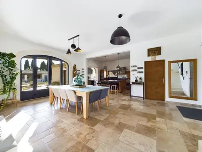 a kitchen and dining room with a table and chairs at Mas des Oliviers in Eyragues
