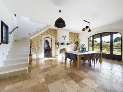 a dining room with a table and chairs and a staircase at Mas des Oliviers in Eyragues