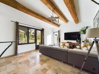a living room with a large couch and a television at Mas des Oliviers in Eyragues