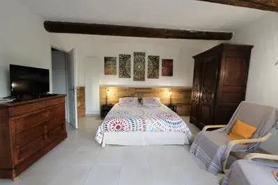 a bedroom with a bed and a dresser and a tv at Gites Provence et Nature - Ambiance familiale et conviviale en Luberon in Cabrières-dʼAvignon