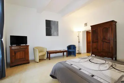 a bedroom with a bed and a tv and a chair at Gites Provence et Nature - Ambiance familiale et conviviale en Luberon in Cabrières-dʼAvignon