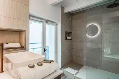 a bathroom with a sink and a glass shower at Appartement Cezanne - Welkeys in Aix-en-Provence