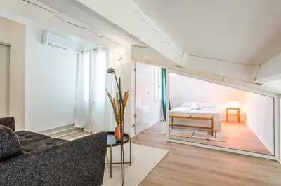 a living room with a couch and a bed at Appartement Cezanne - Welkeys in Aix-en-Provence