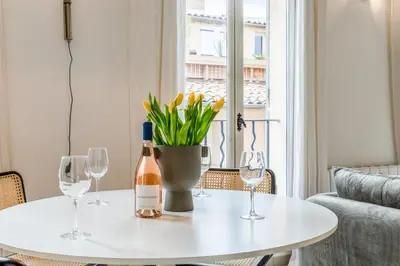 a white table with a bottle of wine and two wine glasses at Appartement Cezanne - Welkeys in Aix-en-Provence