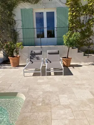 two chairs and a table next to a swimming pool at Chambre d'hôtes de la cime in Cabrières-dʼAigues