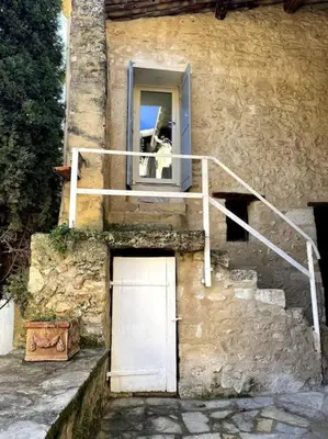 a dog sticking its head out of a window at Maison de caractère au coeur de la Provence in Robion en Luberon