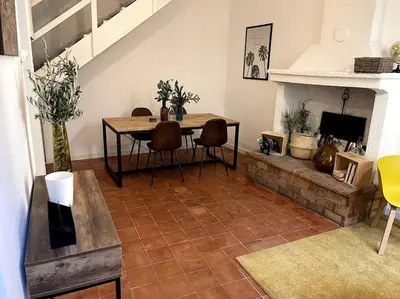 a living room with a table and a fireplace at Maison de caractère au coeur de la Provence in Robion en Luberon