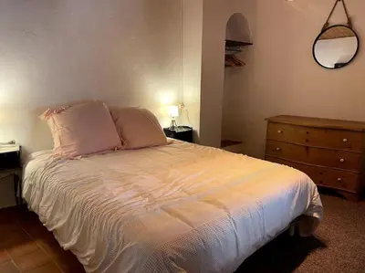 a bedroom with a bed with a dresser and a mirror at Maison de caractère au coeur de la Provence in Robion en Luberon