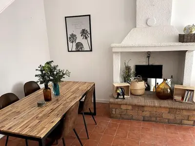 a living room with a wooden table and a fireplace at Maison de caractère au coeur de la Provence in Robion en Luberon