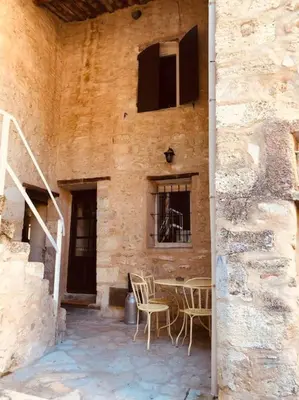 a patio with chairs and a table in a building at Maison de caractère au coeur de la Provence in Robion en Luberon