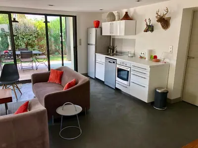 a living room with a couch and a kitchen at Maison contemporaine dans le village d'Eygalières in Eygalières