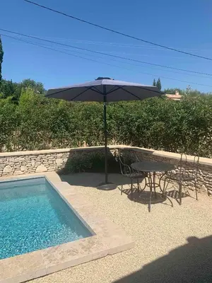a table and an umbrella next to a pool at Le Cabanon de Livia avec piscine privée in Cucuron