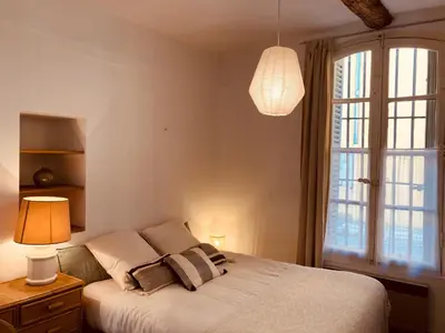 a kitchen with a wooden table and a microwave at Appartement de charme au coeur du vieux Aix. in Aix-en-Provence
