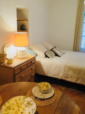 a bedroom with a bed and a table with a lamp at Appartement de charme au coeur du vieux Aix. in Aix-en-Provence