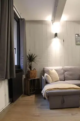 a living room with a couch and a window at Chez Franck et Gisele in LʼIsle-sur-la-Sorgue
