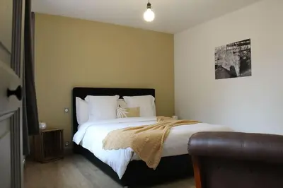 a bedroom with a large bed with white sheets and pillows at Chez Franck et Gisele in LʼIsle-sur-la-Sorgue