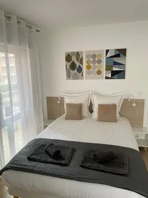 a bedroom with a bed with two towels on it at Aix Homes 