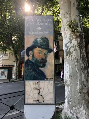a sign next to a tree next to a street at Aix Homes 