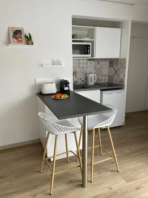 a kitchen with a black table and two chairs at Aix Homes 