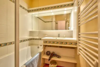 a bathroom with a tub and a sink and a mirror at Village Pont Royal en Provence - maeva Home - Appartement cosy et climatisé 2 pièces 5 personnes avec jardin - Prestige - super Home MAE-2864 in Mallemort