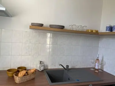 a kitchen counter with a sink and a basket of bread at Cozy Studio with balcony and free parking in Aix-en-Provence