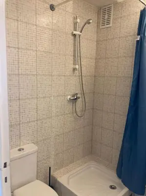 a bathroom with a shower with a toilet and a shower curtain at Cozy Studio with balcony and free parking in Aix-en-Provence