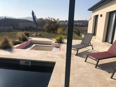 a patio with two chairs and a swimming pool at La Petite Reine in Villes-sur-Auzon