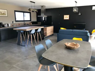 a kitchen and living room with a table and chairs at La Petite Reine in Villes-sur-Auzon