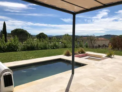 a swimming pool in a patio with an umbrella at La Petite Reine in Villes-sur-Auzon