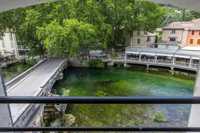 a view from a window of a bridge over a river at Le Château Olive et Raisin in Fontaine-de-Vaucluse