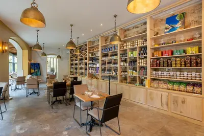 a restaurant with tables and shelves of wine bottles at Le Château Olive et Raisin in Fontaine-de-Vaucluse