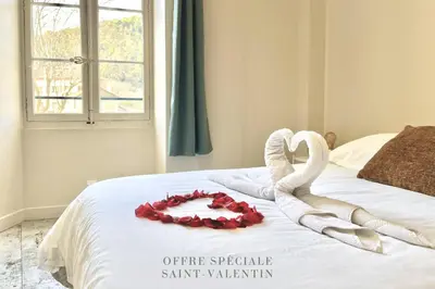 a white bed with a heart made out of towels at Le Château Olive et Raisin in Fontaine-de-Vaucluse