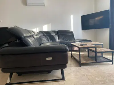 a black leather couch and a table in a room at Luxury House Family’s in Carpentras