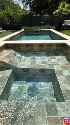 a swimming pool with a tile floor and a fountain at Luxury House Family’s in Carpentras