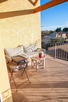 a patio with a couch and a table on a balcony at La Blanchère, vue golf in Vedène