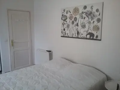 a bedroom with a bed and a picture on the wall at UNE CHAMBRE EN VILLE in LʼIsle-sur-la-Sorgue